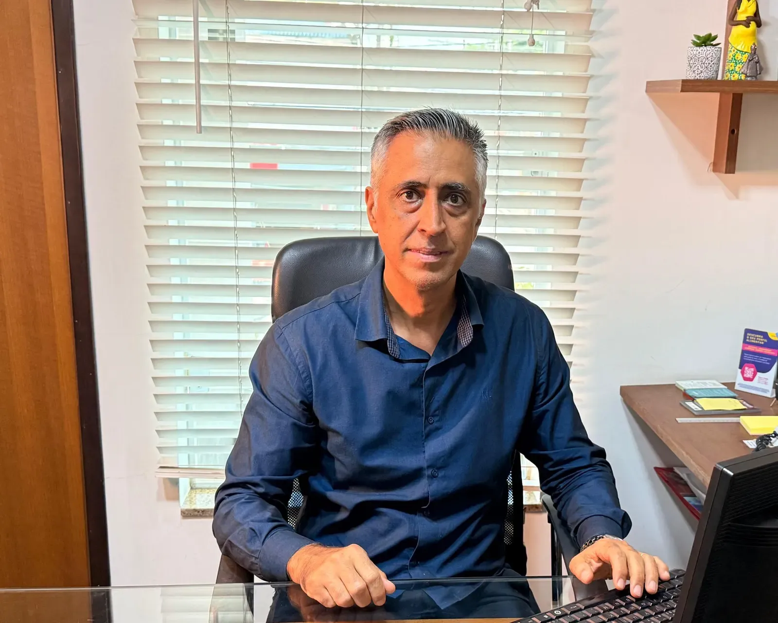 Dr. Alexandre Iglesia sentado em seu consultório