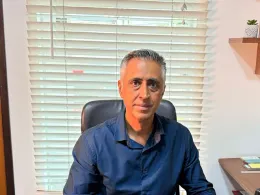 Dr. Alexandre Iglesia sentado em seu consultório, olhando para a câmera
