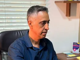 Dr. Alexandre Iglesia atendendo ao computador em seu consultório